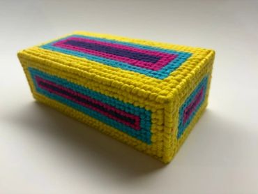 Colorful rectangular crocheted box with geometric patterns.