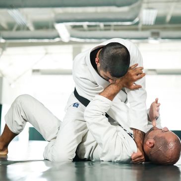 One man choking another man in Gracie Jiu jitsu class