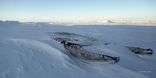 qamutiik half buried in snow, on the sea ice near saniraajak, hall beach, Nunavut