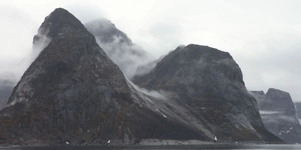 granite peaks pushing though fog and sea, Frobisher bay, Nunavut