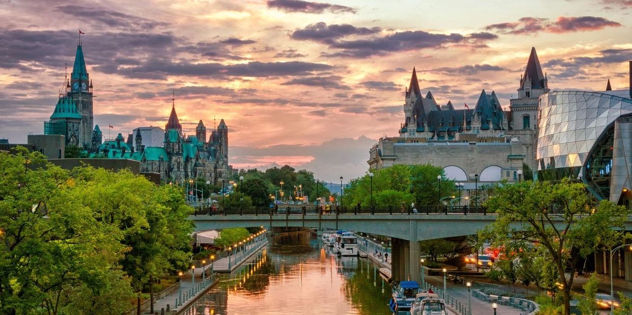 Scenic city canal with historic buildings at sunset.