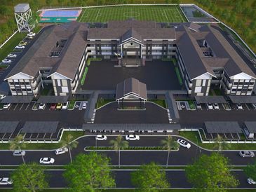 A large modern municipal building complex with parking, sports fields, and greenery.