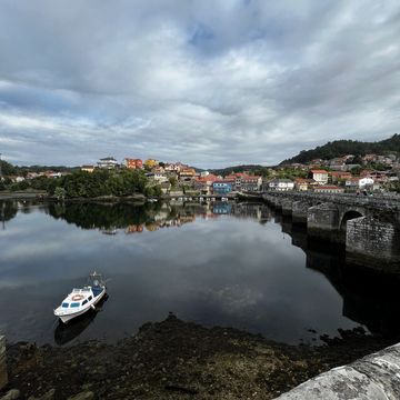 Camino de Santiago, harbor with boat and village. 