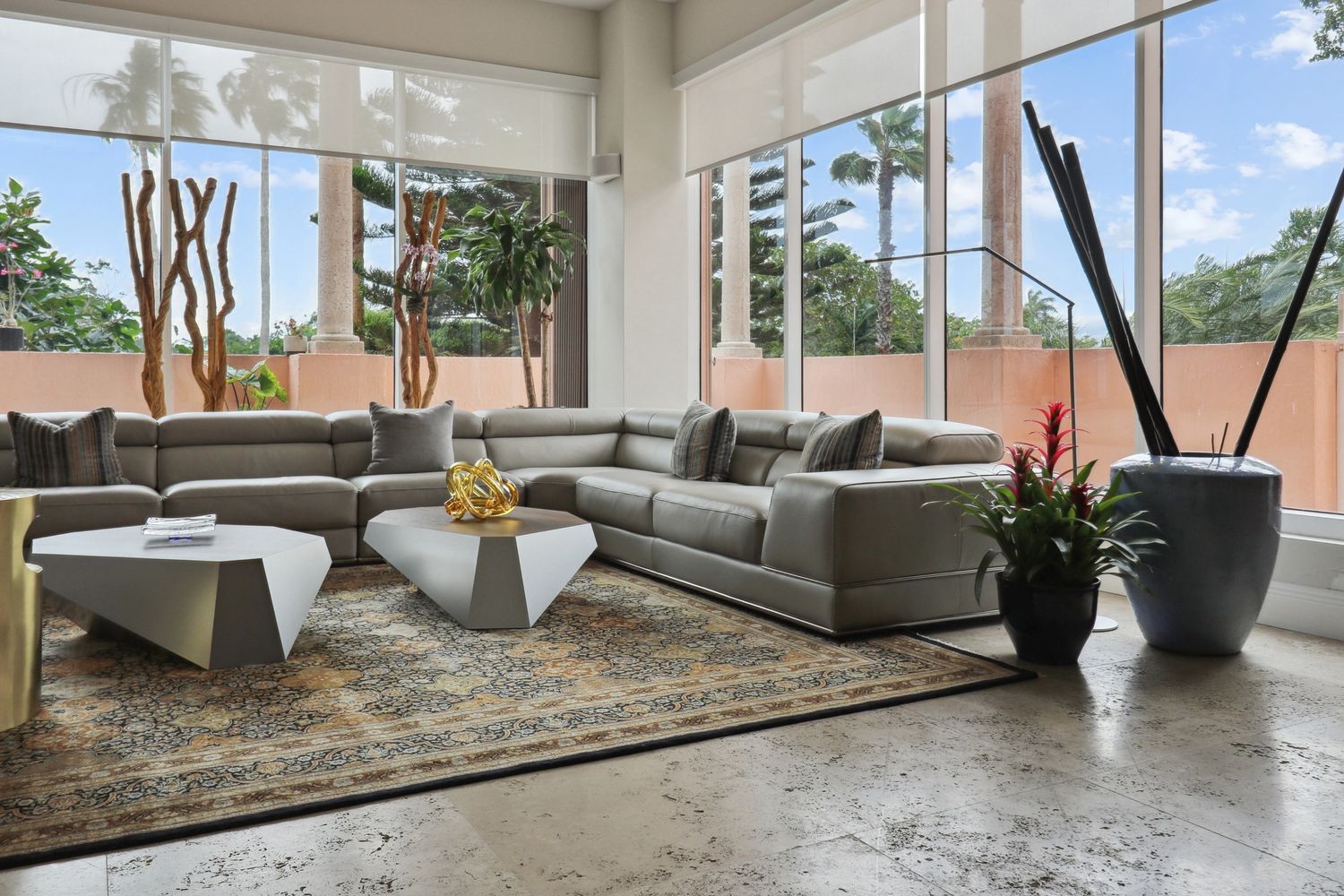 Modern living room with gray sectional sofa and geometric coffee tables.
