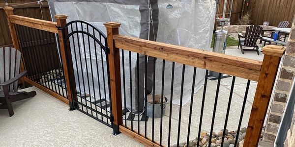 A wooden fence with a metal gate, showcasing a combination of wood and iron materials.
