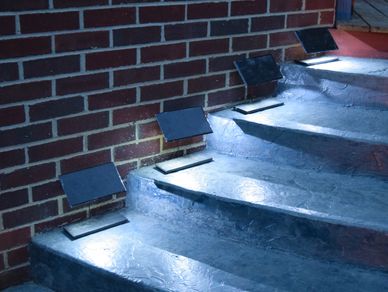 Night photo of four Step Edge Lanterns for outdoor steps and stairways.