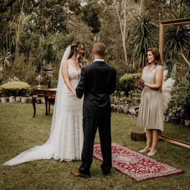 Couple exchanging vows outdoors in a rustic wedding ceremony.