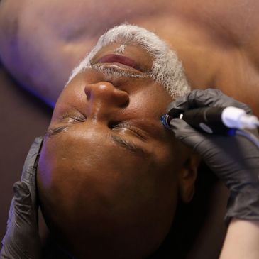 Man with gray beard getting a hydrafacial service at East Village Spa