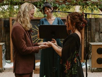 A couple exchanging vows during an outdoor wedding ceremony.