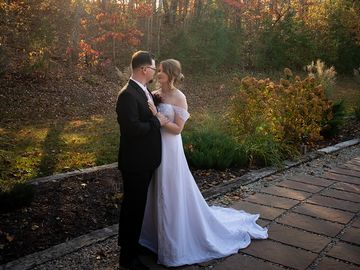Bride and groom share a romantic moment outdoors in autumn.