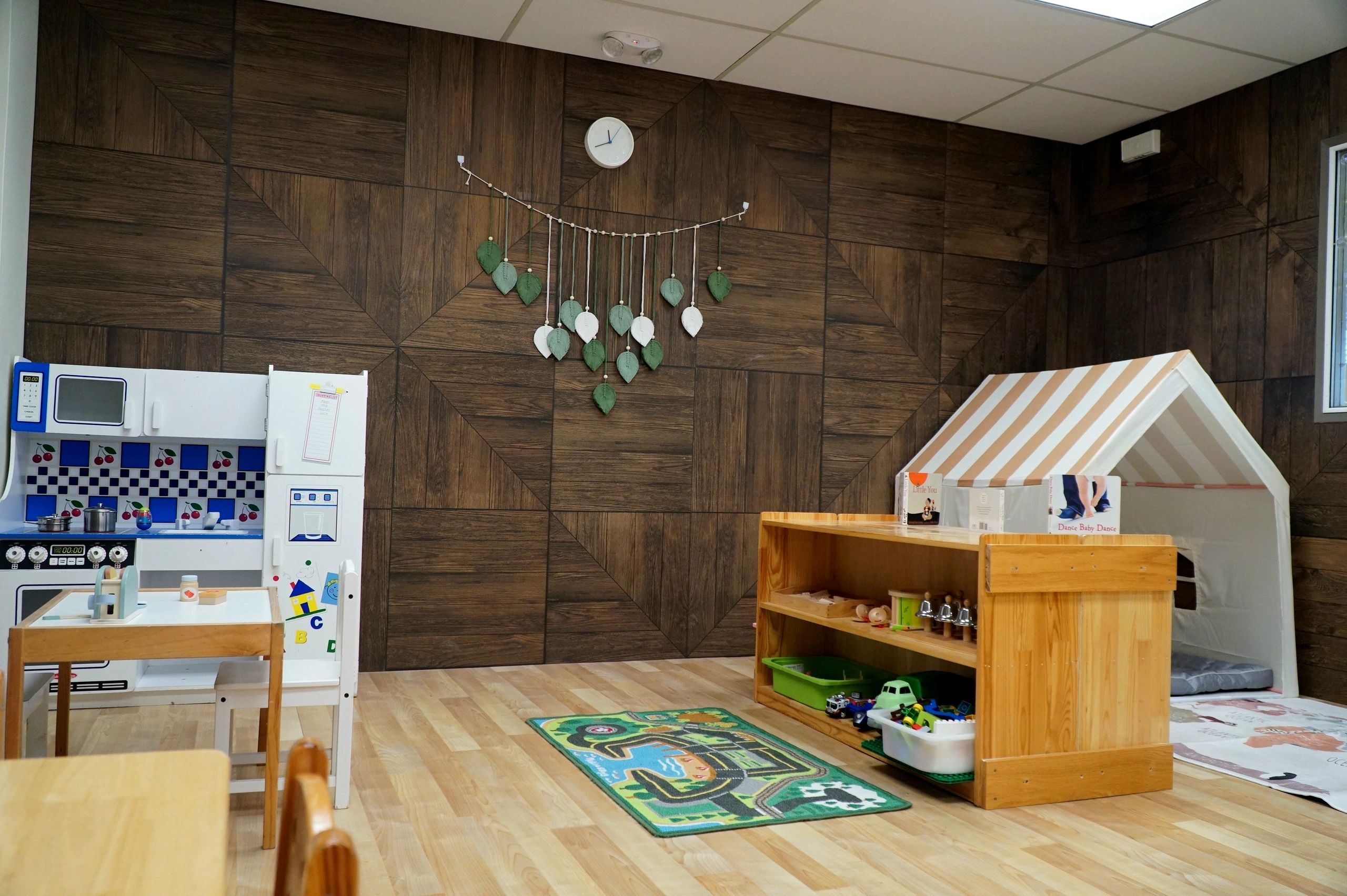 Cozy children's playroom with wooden decor and toy kitchen.
