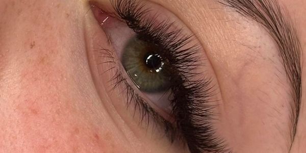 Close-up of an eye with long eyelashes and natural eyebrow.