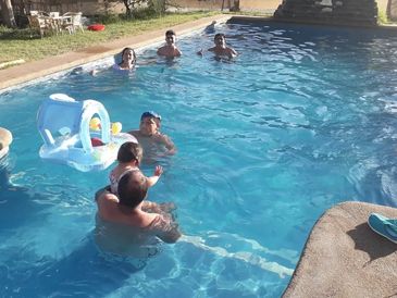 A family is enjoying a sunny day in a swimming pool. 