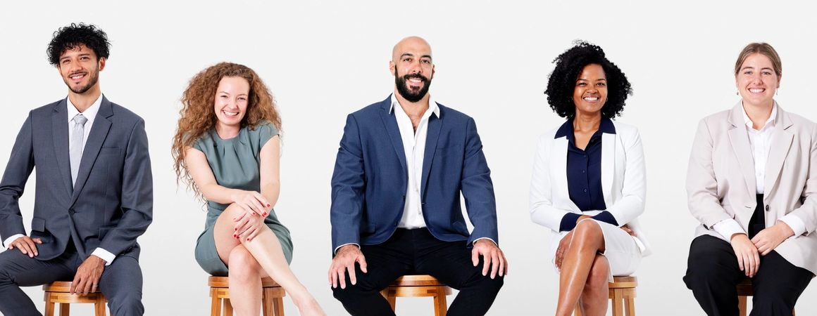 Five diverse professionals sitting together and smiling