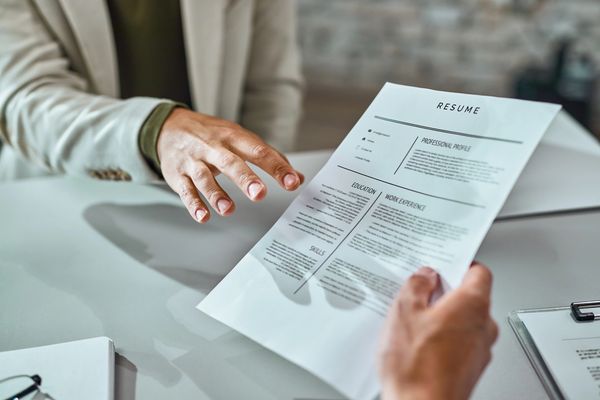 Person handing over a resume during a job interview.