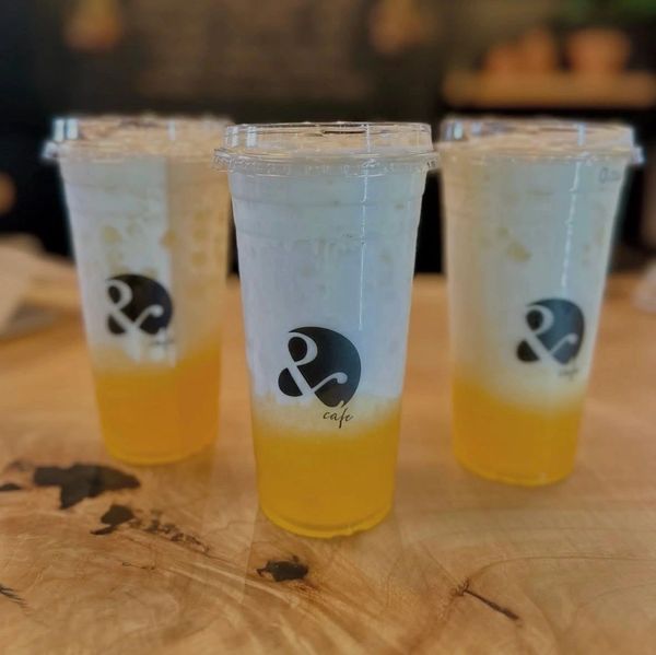 Three iced layered drinks with a cafe logo.