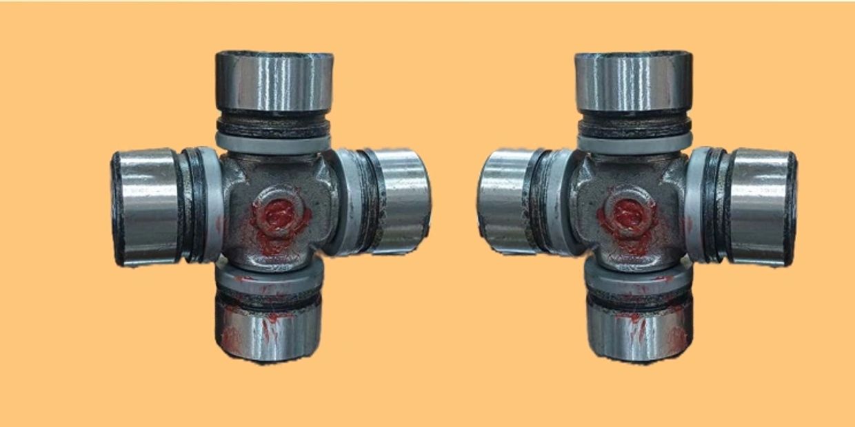 Two identical metal universal joints on an orange background.