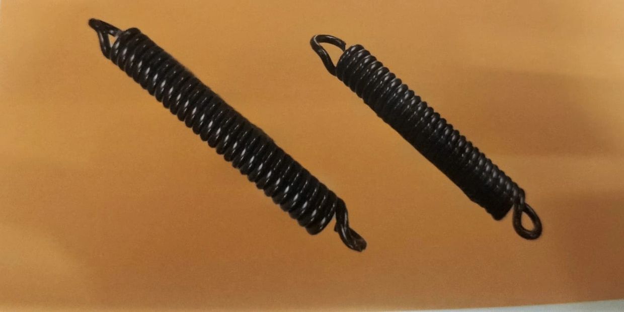 Two black metal tension springs on a beige background.