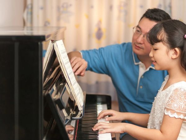 Asian piano teacher and young student