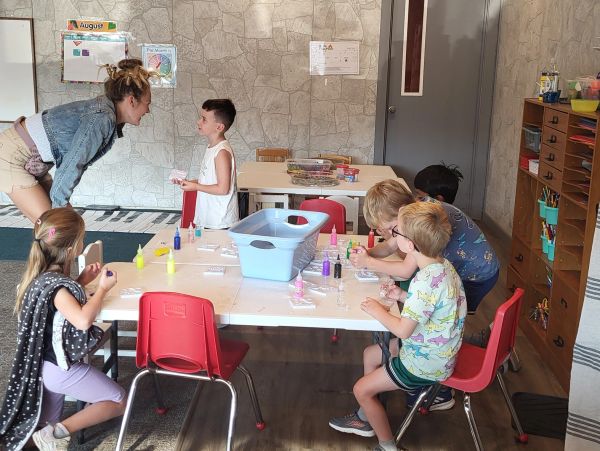 Children and teacher engaged in classroom art activity.