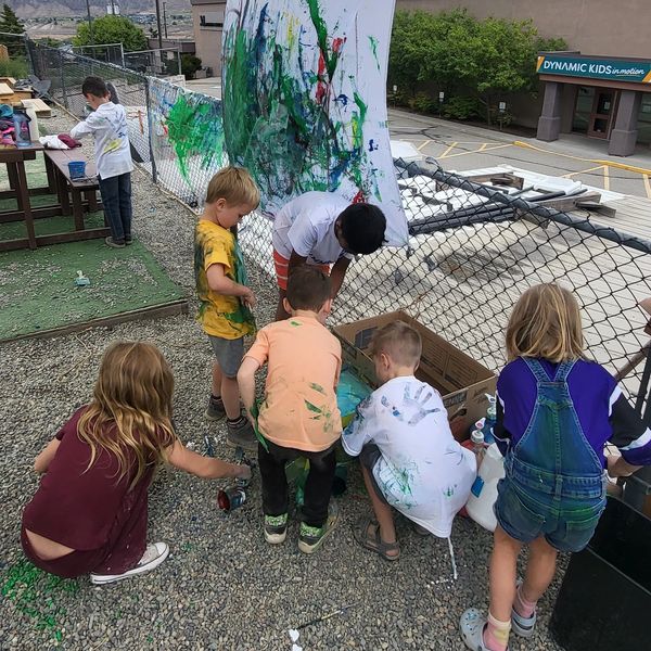 Children engaged in outdoor painting activity.
