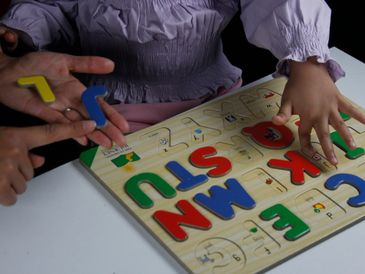 a child completes an alphabet puzzle