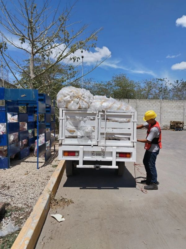 Trabajador descarga bolsas de un camión en un área industrial.