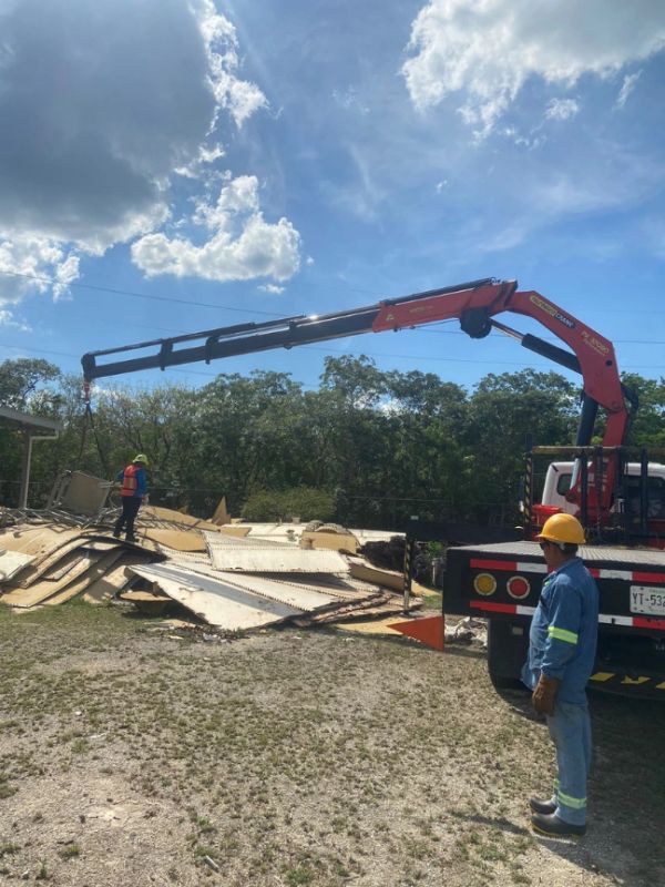 Trabajadores con grúa en obra.