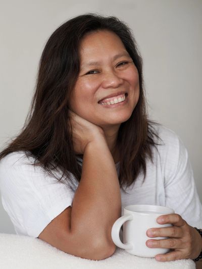 Smiling woman holding a white mug.