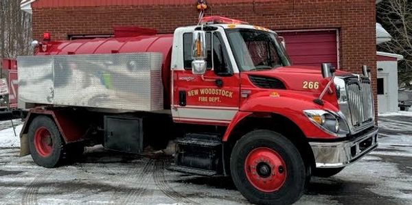 Red fire truck parked outside a fire station.