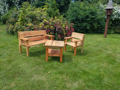 Wooden garden furniture set on green grass near bushes.