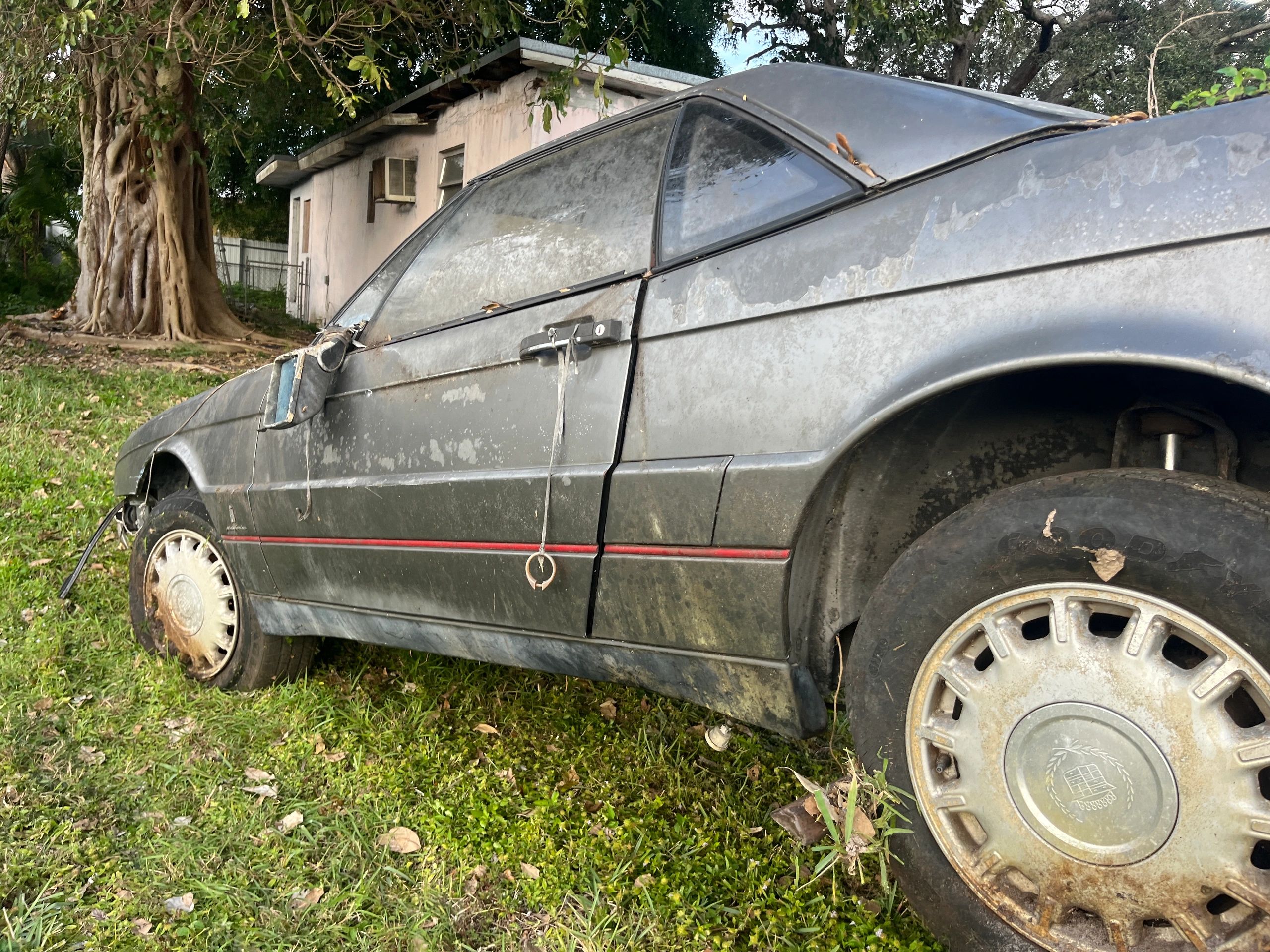 Junk Cadillac being towed from a house that was abandoned. Free pickup and instant clunker removal.