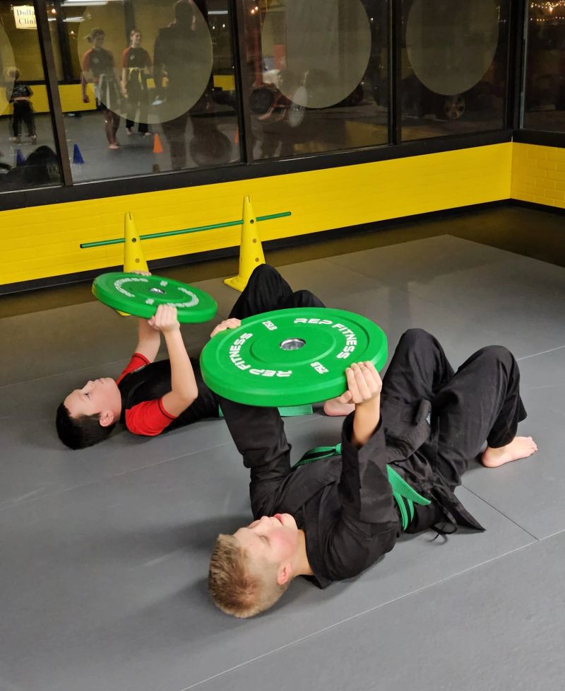 Students pressing bumper plates in fitness training