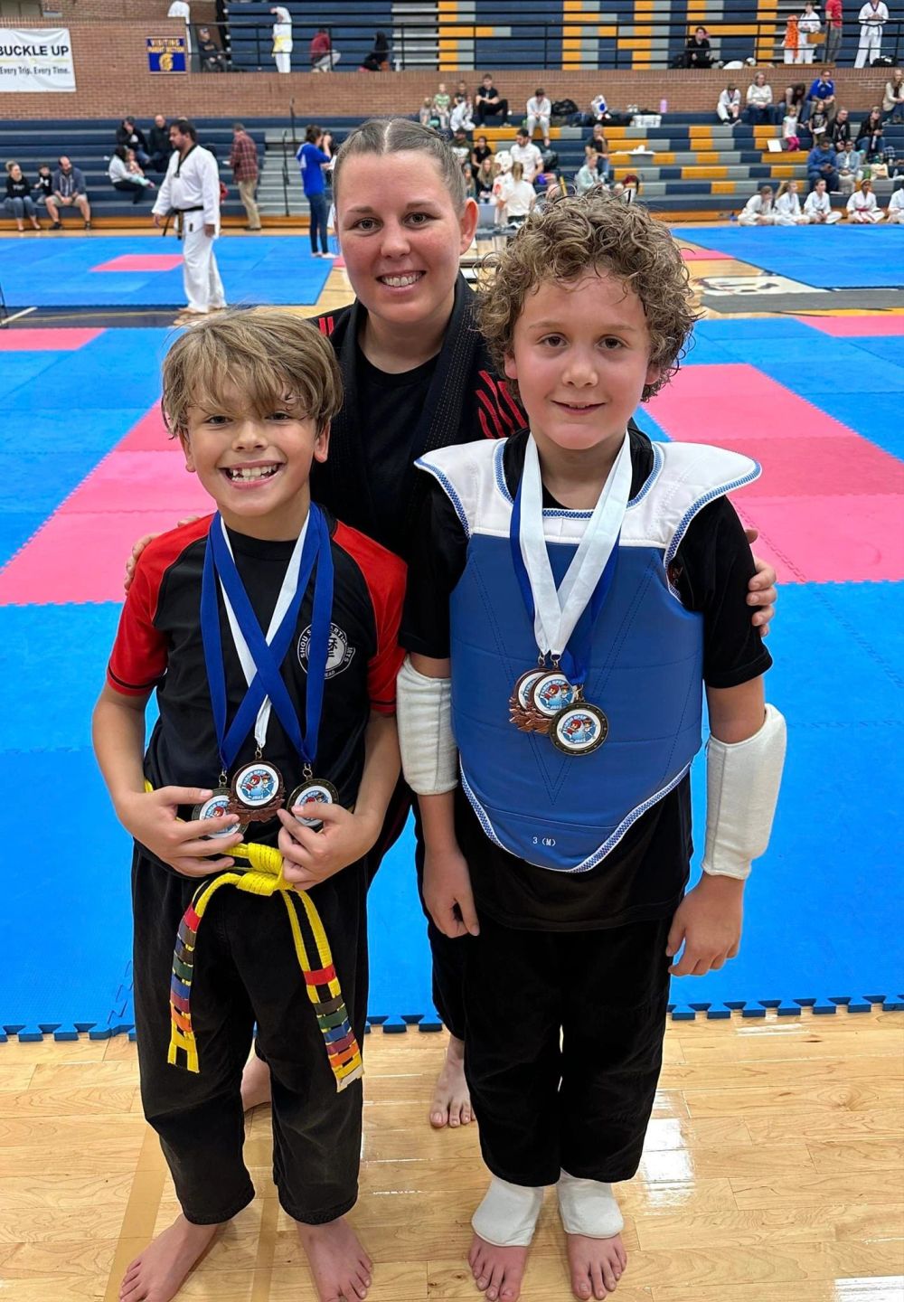 Young students with tournament medals after a jiu jitsu competition
