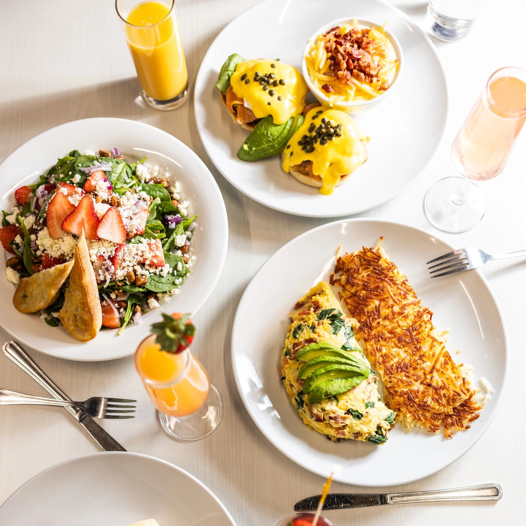 Delicious brunch with eggs, salad, and drinks.
