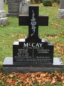 black monument in the shape of a cross
catholic religion
marker
headstone
memorial