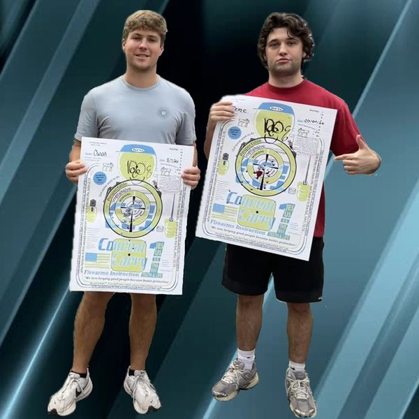 Two young men proudly hold shooting target practice sheets.