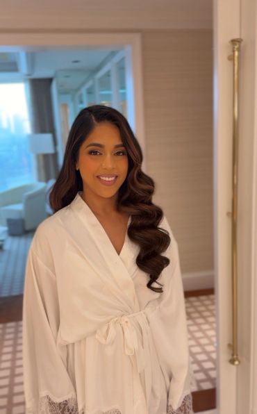 Woman in white robe smiling indoors.