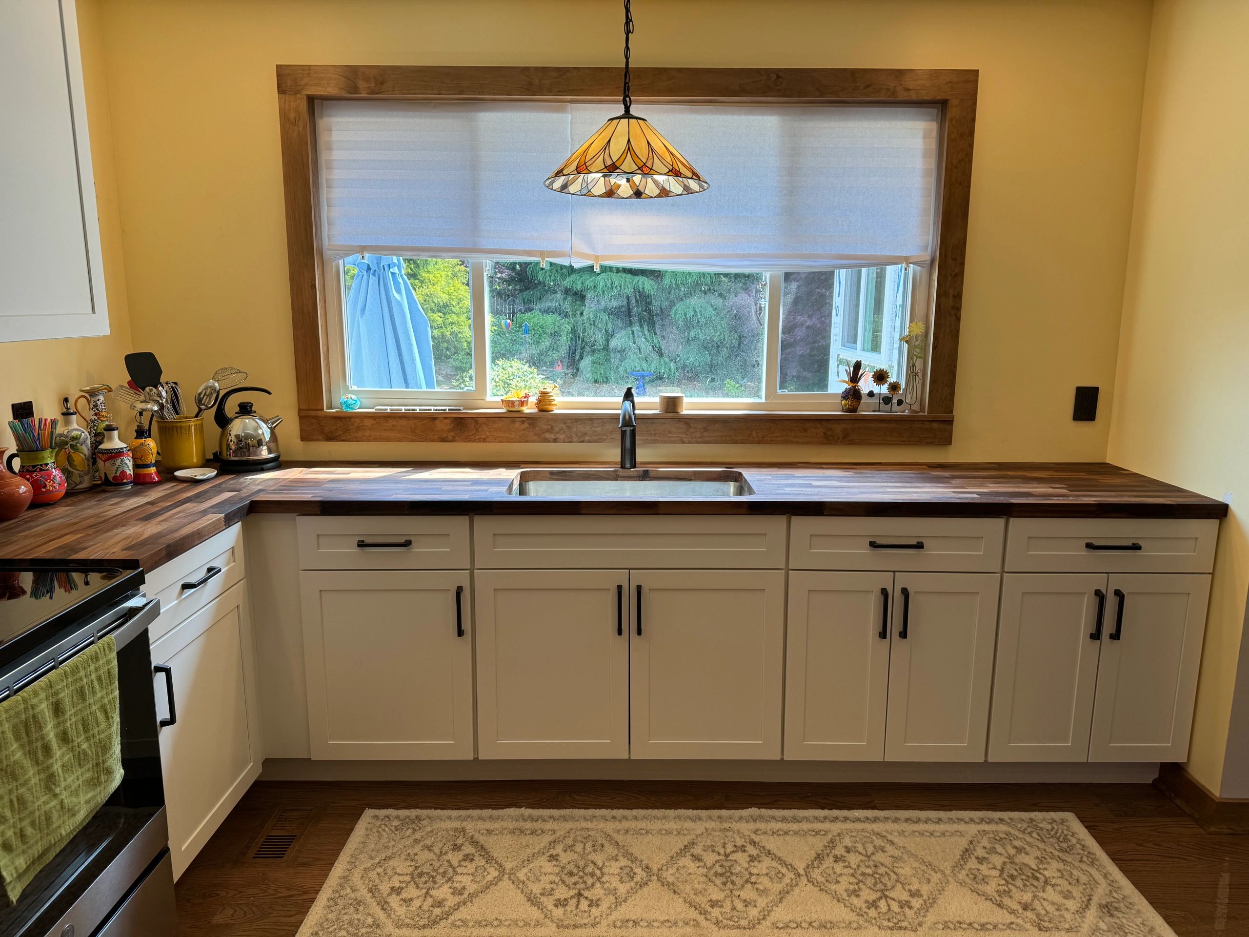 Kitchen Remodel with oak floors, new cabinets, walnut butcher block countertops, and a Pella window.