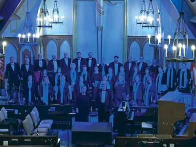 Choir group standing on stage inside a church.