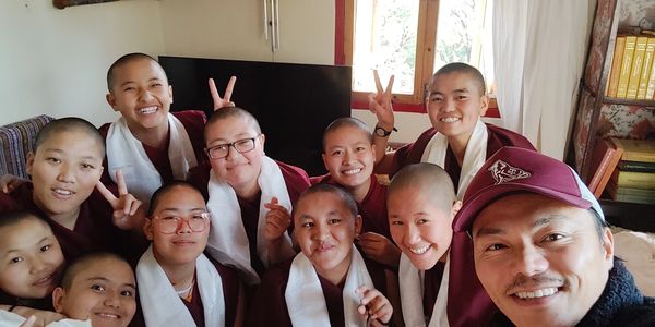 A group photo shows the founder of Munpa Rabsel surrounded by his Buddhist nun students with joyful 