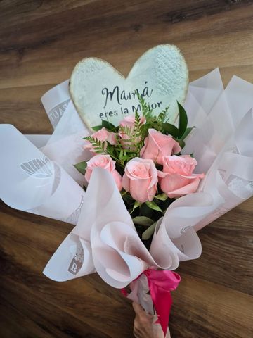 Bouquet of pink roses with a heart-shaped sign saying "Mamá eres la mejor".