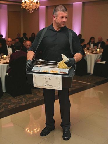 a walking cannoli attendant posing at a wedding