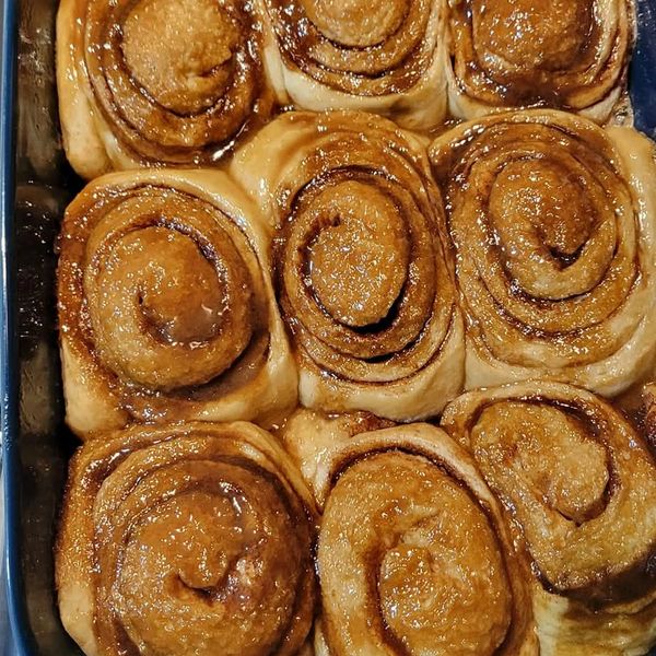 Freshly baked cinnamon rolls in a blue baking dish.