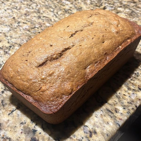 Freshly baked loaf of bread on a granite kitchen counter.
