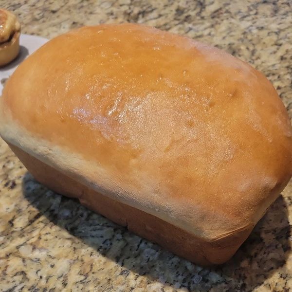 Freshly baked loaf of bread on a granite countertop.