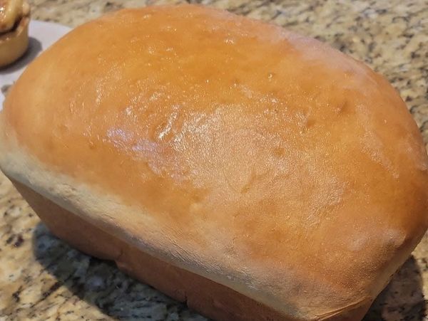 Freshly baked loaf of bread on a granite countertop.