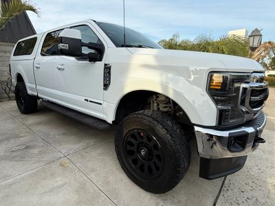 White pickup truck with black wheels parked on driveway.