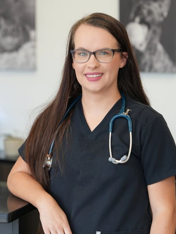 Smiling female healthcare professional with glasses and stethoscope.
