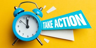 A traditional blue alarm clock on a yellow background with the words "take action"